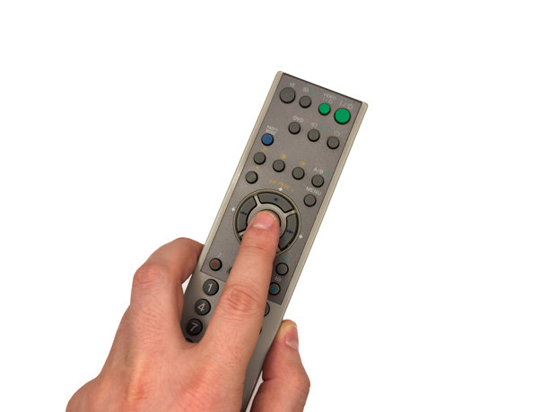 白人男性的手在白色背景上按压旧银色电视遥控器的按钮，男子用遥控器切换电视频道，适用于横幅和电视广告。留白，平铺，俯视图。图片下载