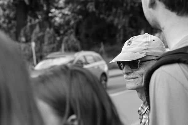 户外微笑的戴帽子和太阳镜的老人，黑白照片图片下载