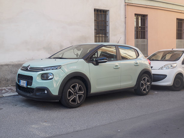 薄荷绿的雪铁龙C3停靠在复古的欧洲建筑旁，展示了现代汽车设计与历史城市街景的对比。图片下载