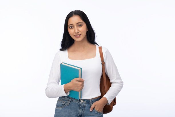 年轻女学生背着书包，穿着现代服装，独自站在白色背景前的照片图片下载