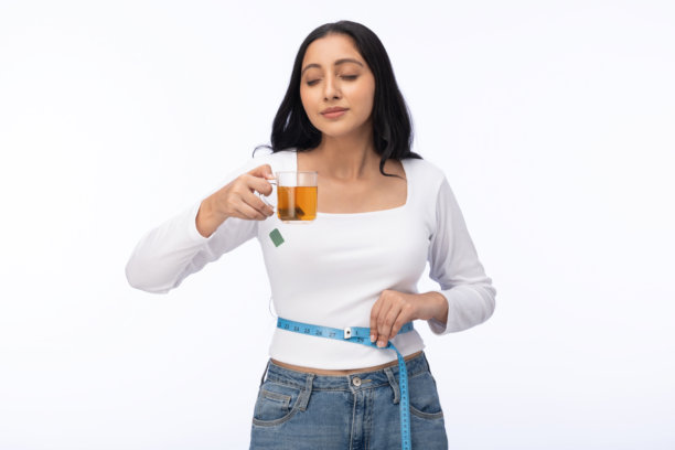 年轻女性穿着T恤在白色背景下喝绿茶的照片图片下载