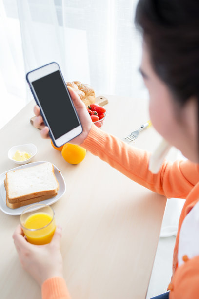 女人用智能手机拍摄早餐照片图片下载