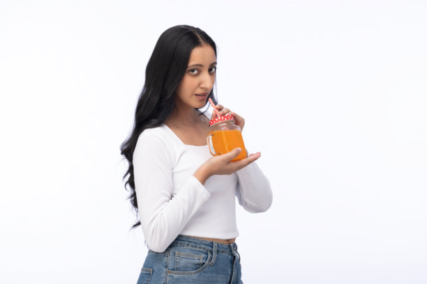 夏季漂亮游客在白色背景下喝果汁的肖像照片图片下载