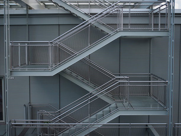 极简主义钢制消防逃生楼梯 - 一幅全景、细致的现代建筑干净、极简的钢制消防逃生楼梯的照片，突显其几何和工业设计。图片下载