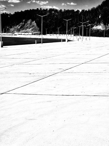 现代海滨。平静的水面，混凝土码头和现代街灯。黑白照片图片下载