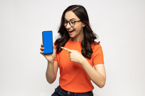 穿着橙色T恤的年轻女性展示设备屏幕的照片，背景为白色。图片下载