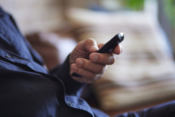 一位日本老人的手握着电视遥控器图片下载