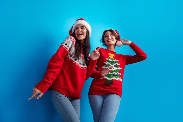 快乐女孩在圣诞派对上跳舞的照片，低角度拍摄，背景为蓝色。图片下载