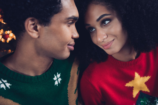 亲密的照片，迷人而充满爱的理想情侣在室内依偎在一起，享受圣诞节的氛围。图片下载