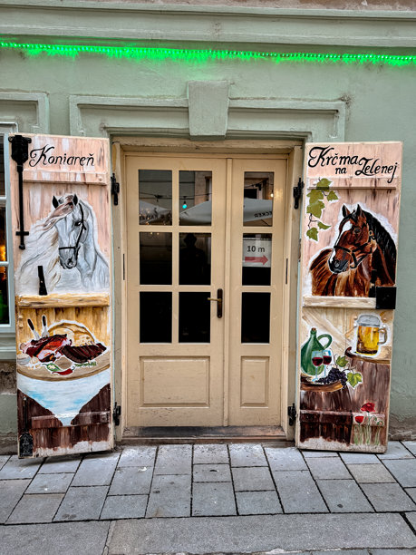 手绘木百叶窗装饰着“Krčma na Hlavnej”的入口，这是一家位于布拉迪斯拉发历史中心的舒适酒馆。图片下载