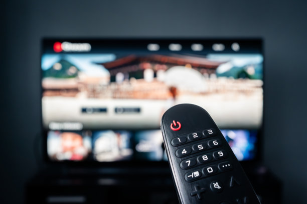 在家观看电影的电视流媒体。流媒体服务，视频点播系列。家庭电影之夜。电视屏幕。遥控器。视频点播内容的订阅。图片下载