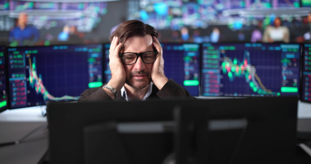 金融交易员焦虑地在多个屏幕上监控股市崩盘图片下载