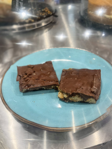 自制巧克力饼干蛋糕的图片，烘焙盘装在面包店或咖啡馆中，适合午餐盒或下午茶，丰富的甜点，温馨的咖啡店图片下载