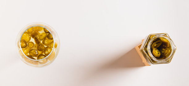 白酒杯中盛放的绿色墨西哥辣椒切片，桌面俯视图网络横幅图片下载