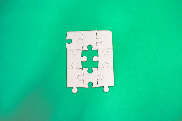 一幅引人注目的俯视角工作室照片，展示了白色拼图与生动的绿色背景。图片下载