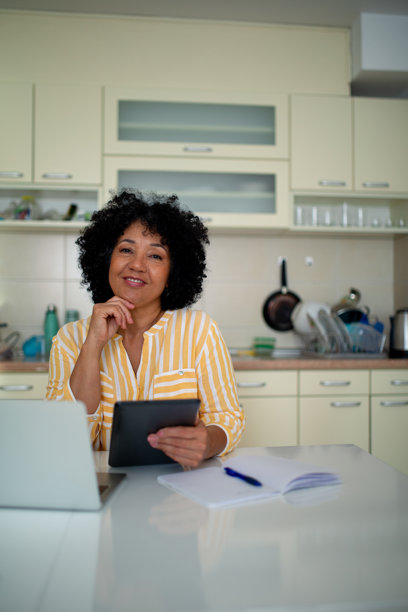 在家使用平板电脑工作的微笑女性 - 股票照片图片下载