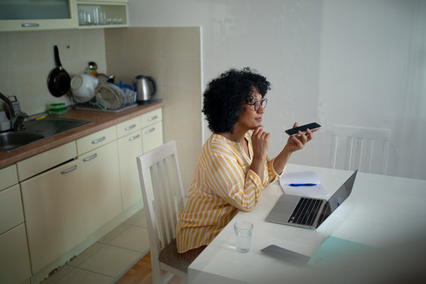 在家工作的女性通过扬声器通话 - 股票照片图片下载