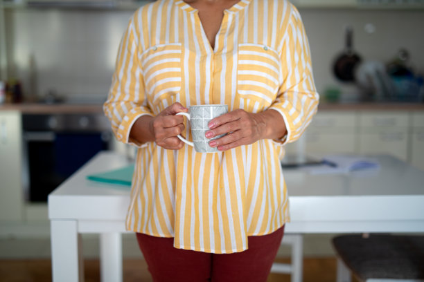 女人在家厨房里拿着咖啡杯 - 股票照片图片下载