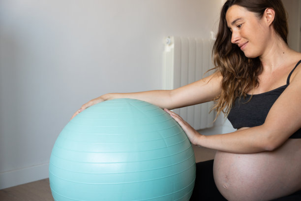 孕妇在家用普拉提球做运动图片下载