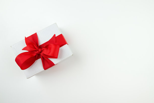 白色礼品盒顶部视角照片，配有红色丝带蝴蝶结，背景为纯白色，留有空白区域。图片下载
