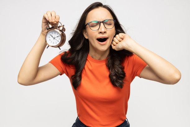 年轻女子与闹钟的隔离照片，背景为白色图片下载