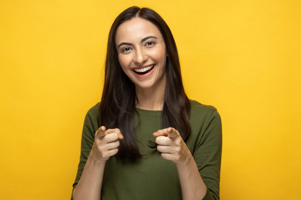 身穿绿色T恤的年轻女子肖像，独立于黄色背景的素材照片图片下载