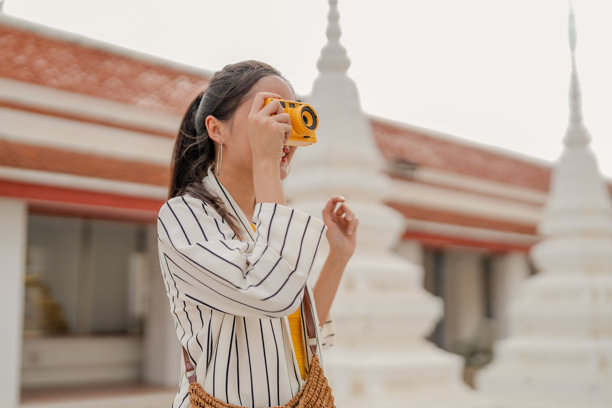 独自旅行的亚洲女性探索古老寺庙建筑，在拥抱漫游精神的变革之旅中，发现世界文化遗产和圣地，并拍摄令人惊叹的照片。图片下载