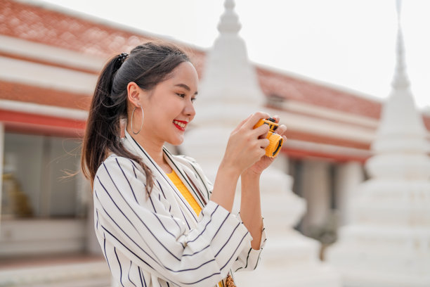 一名亚洲女性旅行者独自探索古老的寺庙建筑，在拥抱漫游癖精神的变革之旅中，通过拍摄令人惊叹的照片来发现世界文化遗产和圣地。图片下载