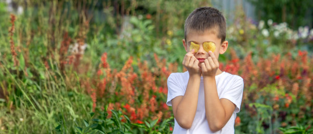 男孩从零食包装袋里吃薯片。不健康的食物概念图片下载