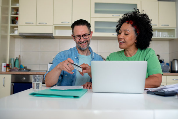 年长的夫妇使用信用卡进行在线支付和购物的素材照片图片下载