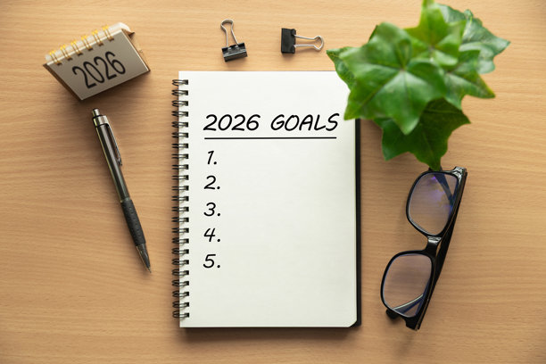 笔记本，标题为“2026年目标”，上面有空白清单，放在木桌上，配有钢笔、眼镜、迷你日历和笔记本电脑，是新年生活和商业目标规划、策略以及个人成长等的理想素材。图片下载