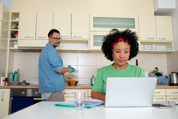 情侣在家工作并在厨房做家务 - 库存照片图片下载