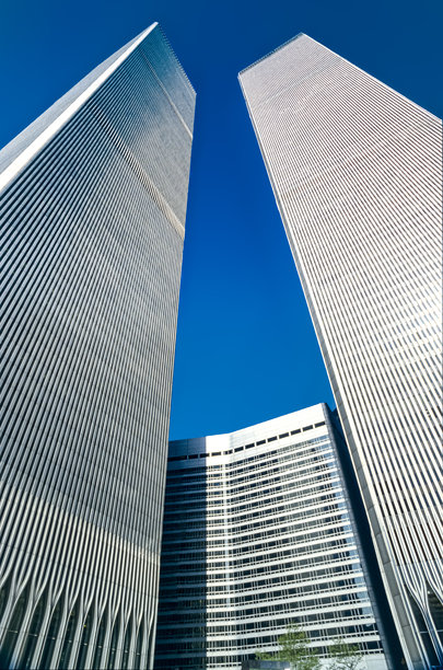 一只青蛙视角的扫描幻灯片，展示了纽约世贸中心（World Trade Center）在9.11.2001恐怖袭击中被毁的历史彩色照片，背景是晴朗无云的蓝色天空。图片下载
