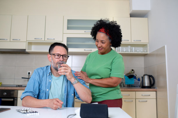 成熟的成年男子在妻子支持下服药 - 库存照片图片下载