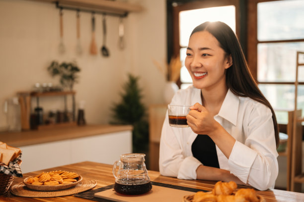 Smiling Woman Enjoying Coffee in the Kitchen图片下载