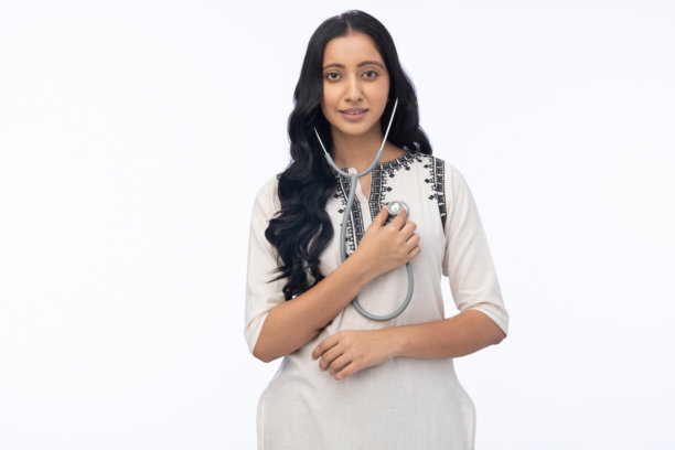 年轻女医生戴着听诊器，身穿印度库尔塔服，在白色背景下拍摄的库存照片图片下载