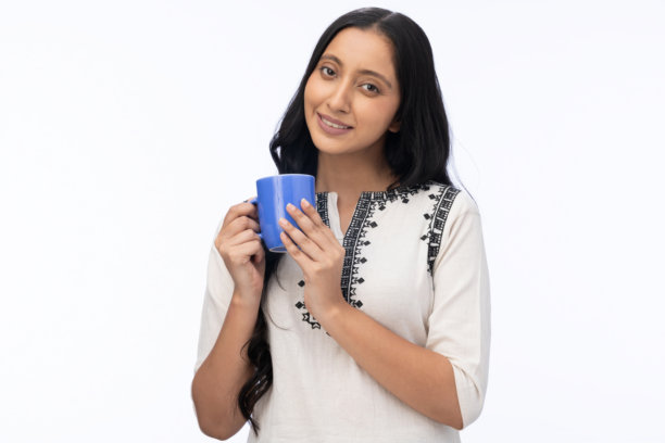 身穿库尔塔服饰的年轻女子饮用咖啡的肖像，白色背景孤例图片图片下载