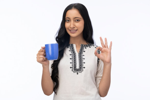 身穿库尔塔服饰的年轻女子饮用咖啡的肖像，白色背景独立素材图片下载