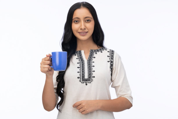 身穿库尔塔的年轻女子饮用咖啡的肖像，在白色背景下分离的素材照片图片下载