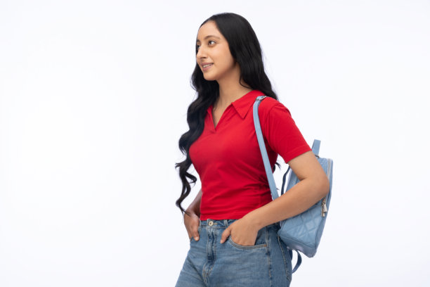 年轻的女学生，身穿现代服装，背着包，在白色背景上孤立，素材照片图片下载