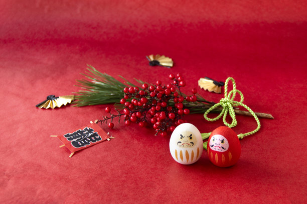 新年日式插画。红白达摩、南天竹和松树，背景为红色。图片下载