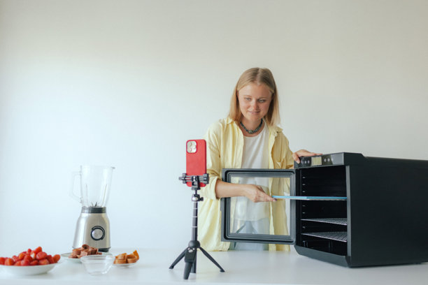 中年女子在厨房准备自制水果干，切新鲜水果制作健康零食。该图片属于有机零食和自然生活系列。用户生成内容。直播图片下载
