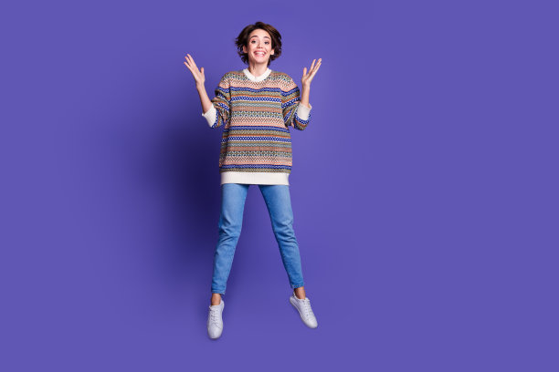 照片：一个穿着时尚套头衫的快乐可爱女人，背景是紫色图片下载