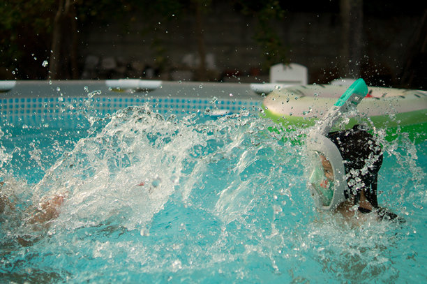 男孩戴着潜水镜被溅起的水花打湿的照片图片下载