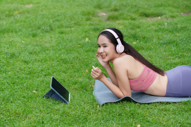 一位女士在休假日于公园里开心地做瑜伽锻炼（照片）。图片下载