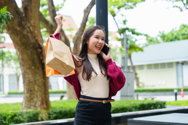 休息日，女子正在用手机享受在线购物，同时听着音乐（照片）图片下载