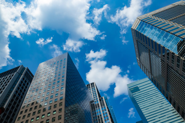 商务区高楼林立的城市景观，云朵倒映着办公楼，广角镜头拍摄。图片下载
