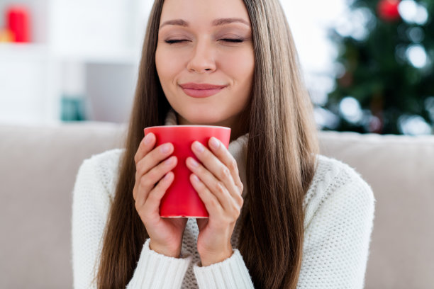 照片，梦幻般快乐的年轻女子，手拿咖啡杯，闻着圣诞节室内房屋公寓的气味图片下载
