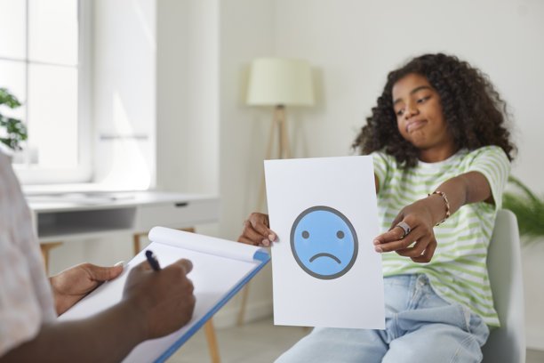 伤心、压力大的孩子向治疗师或学校心理学家展示不开心表情的图片图片下载