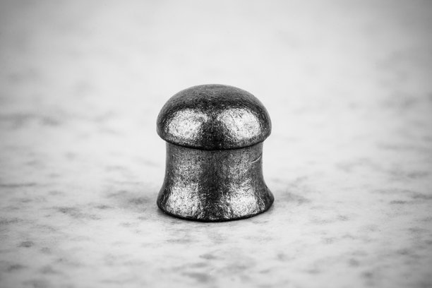 灰色背景下用于气枪的铅弹，黑白特写照片图片下载